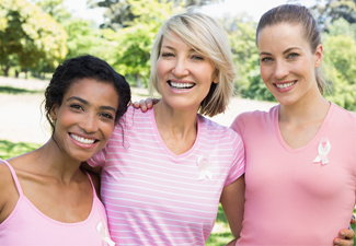 three women wearing breast cancer ribbons
